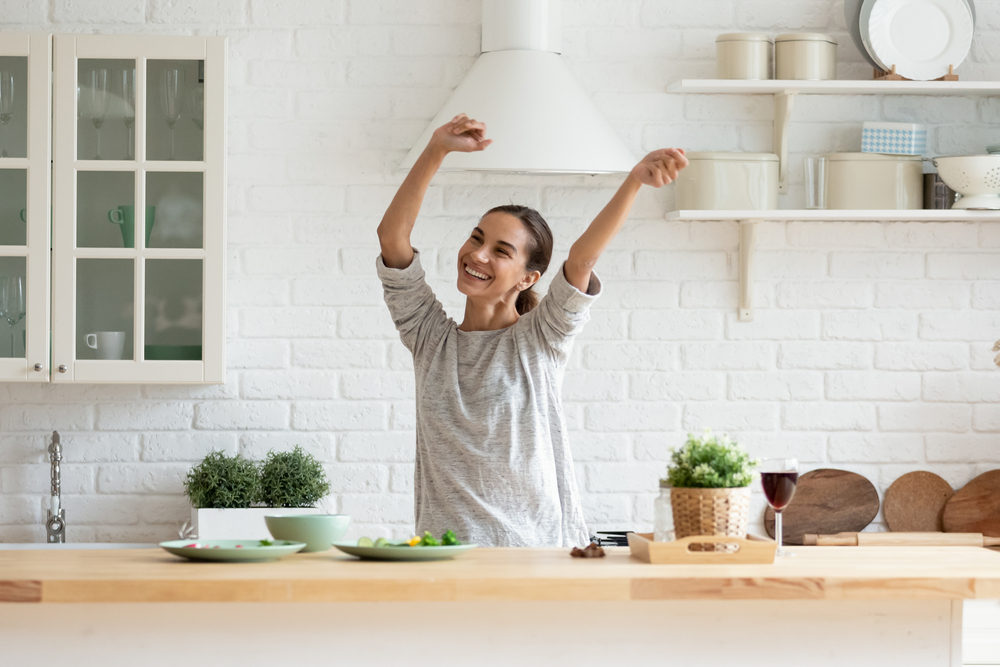 Happy woman in remodeled kitchen (How to Remodel a Kitchen (and How to Get Help))